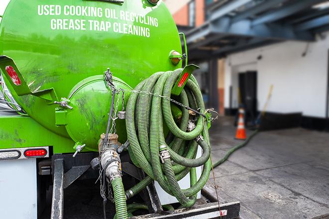 a grease trap being pumped by a sanitation technician in Richmond, RI